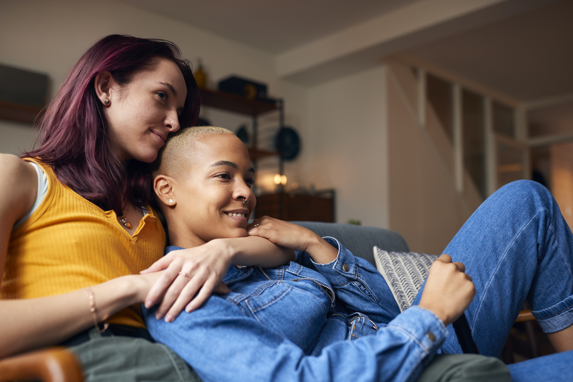 Same sex female couple sitting on sofa and relaxing